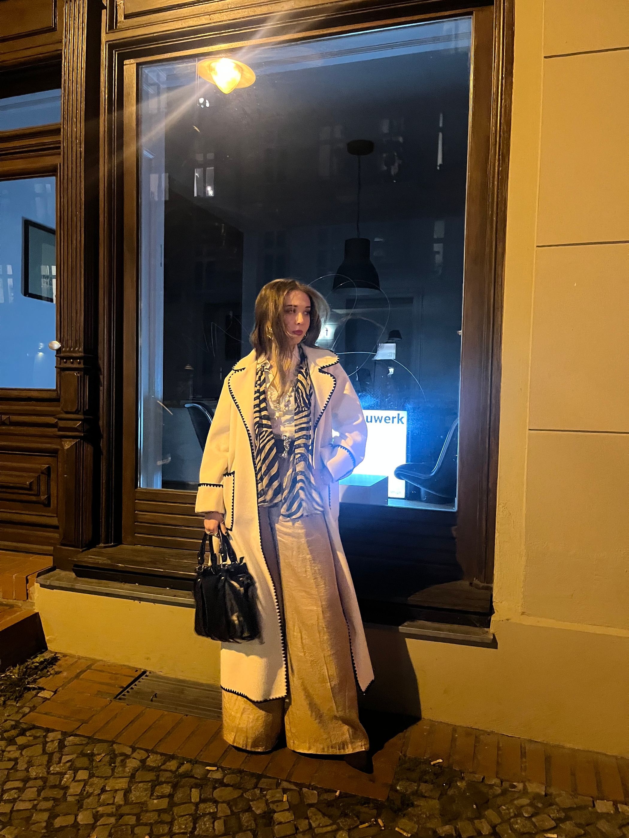 Cherubina Wegner abends vor einem beleuchteten Schaufenster.