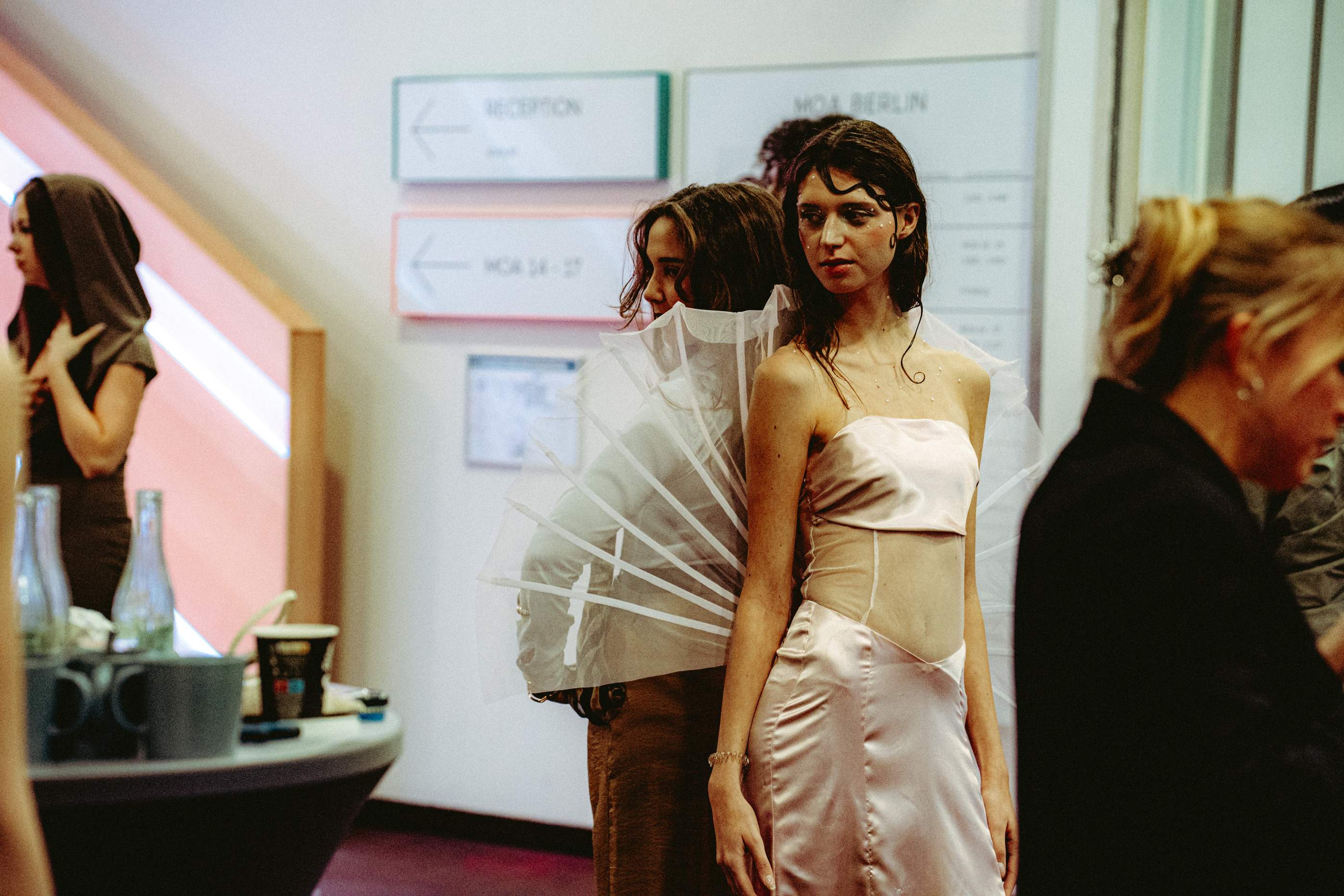 Models warten backstage in ihren Looks auf den Auftritt.