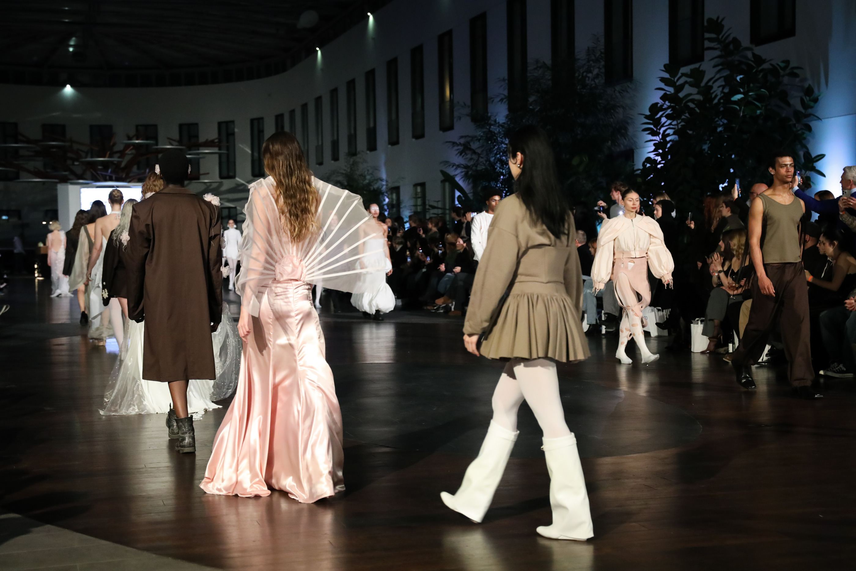 Laufsteg der Show: das Model in der rosa Robe zwischen weiteren Looks der Kollektion.