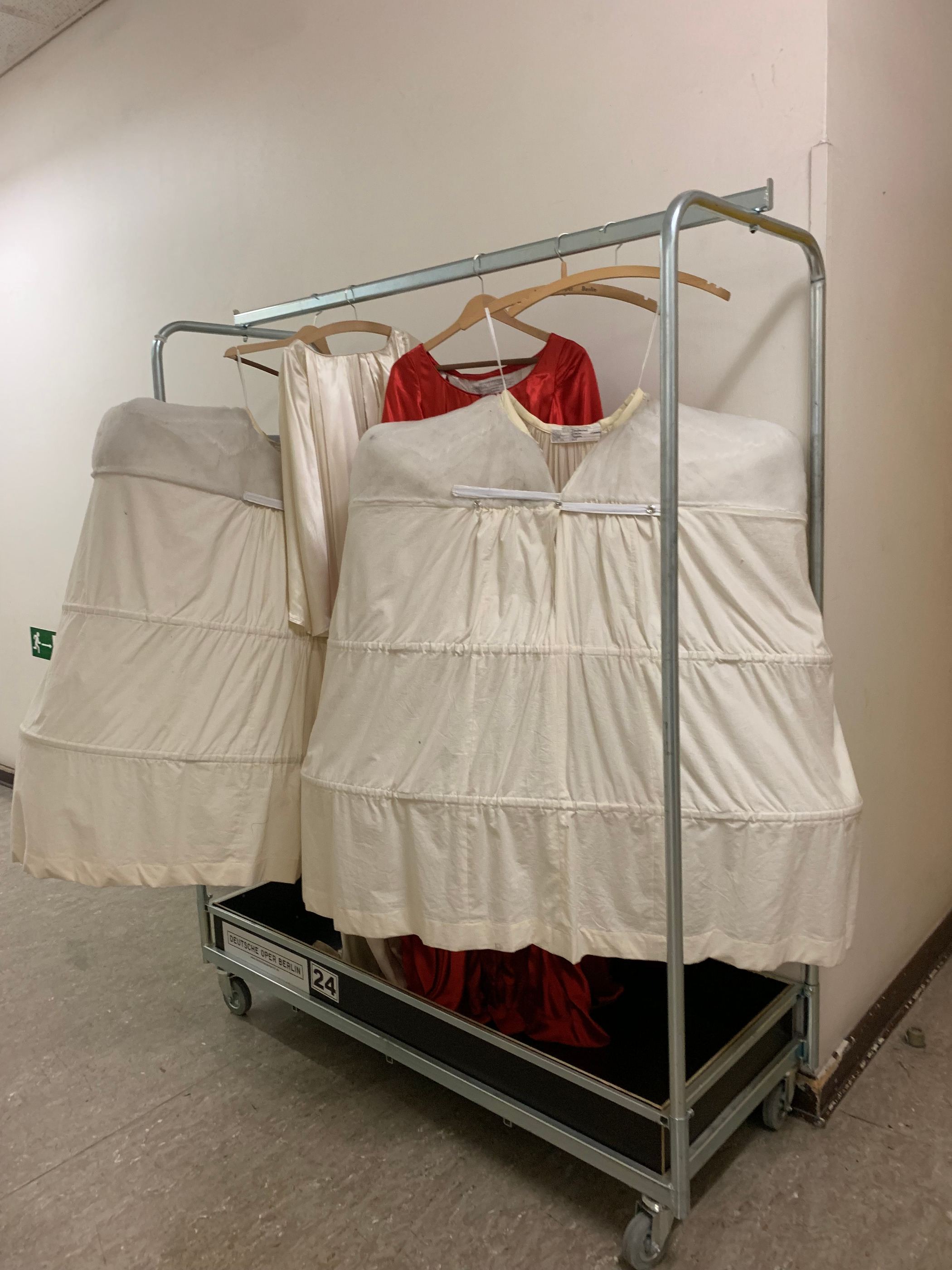 Rollständer der Deutschen Oper Berlin mit Reifröcken und Kostümen in einem Flur.