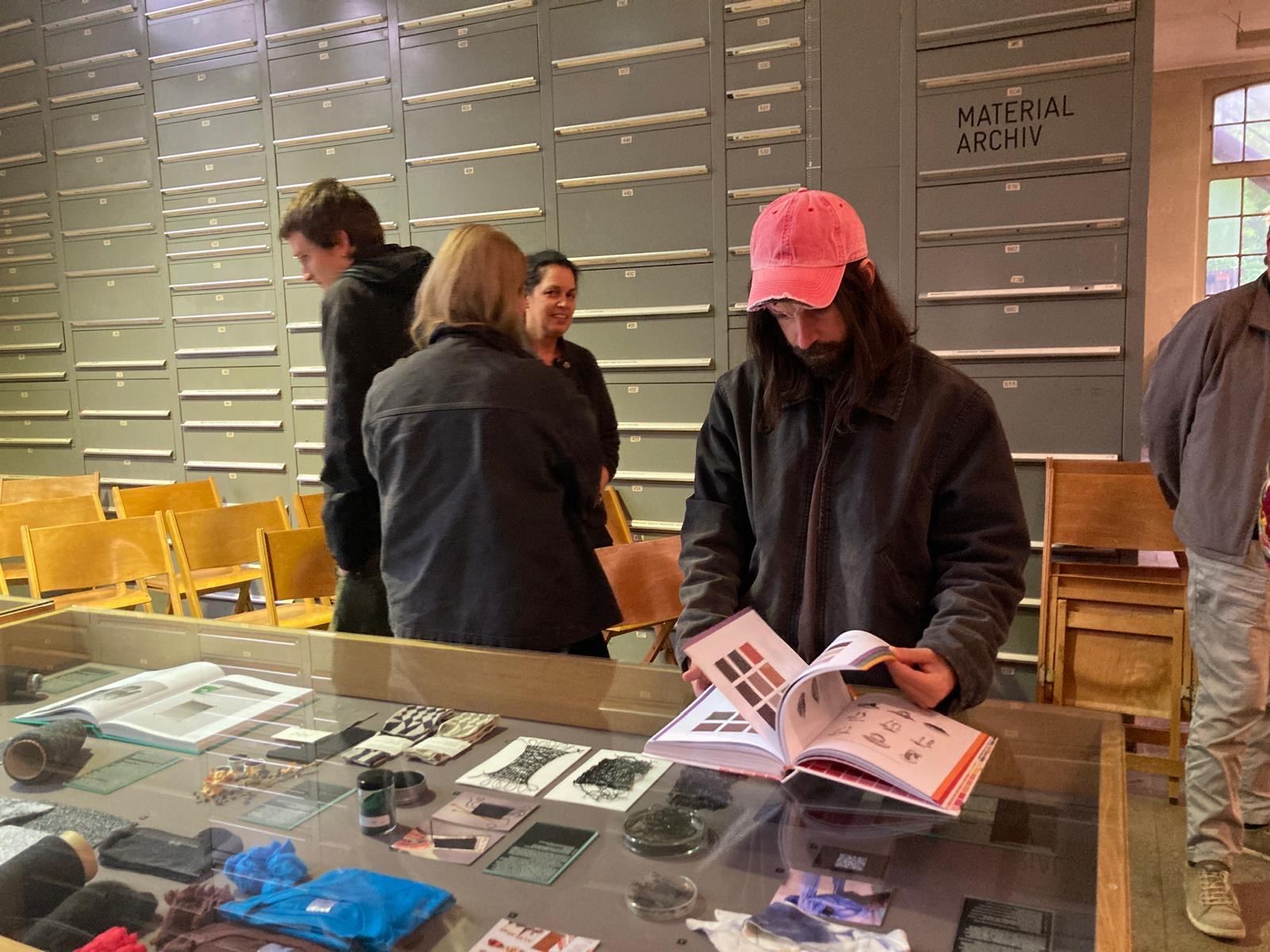 Besucherinnen und Besucher am Schaukasten des Werkstoffarchivs.
