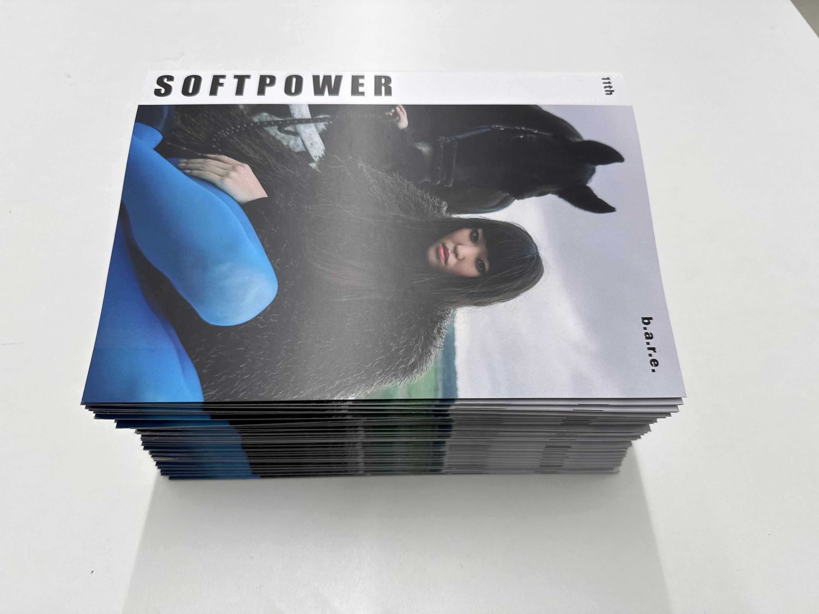 Stapel des gedruckten Magazins mit dem Titel Softpower auf hellem Untergrund.