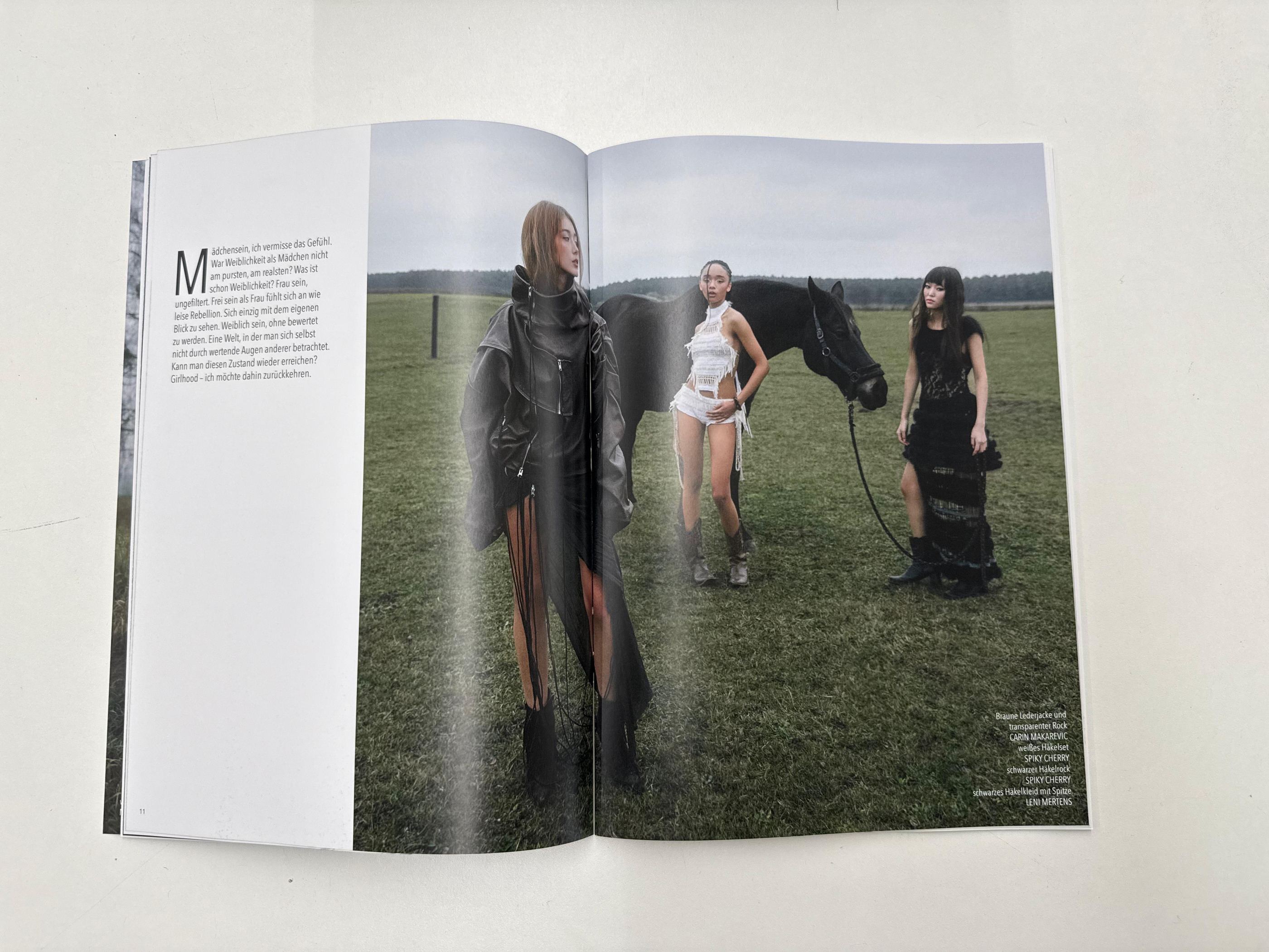 Magazin-Doppelseite mit einer Aufnahme dreier Models mit Pferd auf der Koppel.